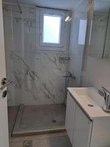 a bathroom with a shower and a sink at Stella Apartments in Néa Péramos +22 photos