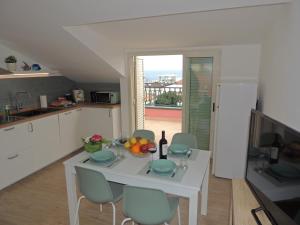 Una cocina con una mesa blanca con un bol de fruta. en LA SCOGLIERA - Apartment, en Stazzo