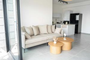 een woonkamer met een bank en twee tafels bij O&O Group Luxury Tower 4BR Panoramic Sea Views in Bat Yam