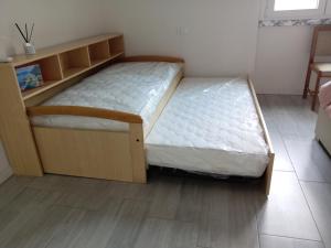 un letto in una camera con telaio in legno di Carlotta House-LT a Bellano