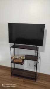 a flat screen tv on a stand in a room at l'Escale in Athis-Mons