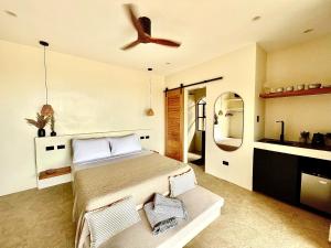 a bedroom with a bed and a ceiling fan at Siroco Villas - Romantic Privet Pool Escape in Tagibo