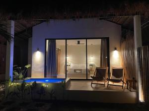 a room with two chairs and a bed at night at Siroco Villas - Romantic Privet Pool Escape in Tagibo