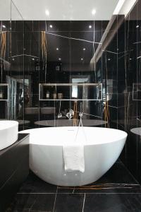 a large white tub in a black bathroom at SkyView Apartment Unic, Select, Ultimul Etaj, Confort Premium în Royal Town Copou in Iaşi