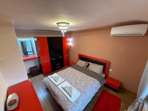 a small bedroom with a bed and a red wall at Two-Bedroom Apartment in the Heart of Burgas, Bogoridi Street in Burgas City