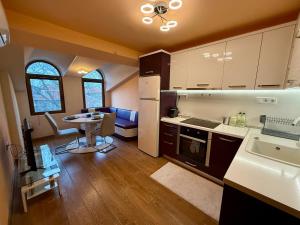 a kitchen and dining room with a table and a kitchen and a dining room at Two-Bedroom Apartment in the Heart of Burgas, Bogoridi Street in Burgas City +9 photos