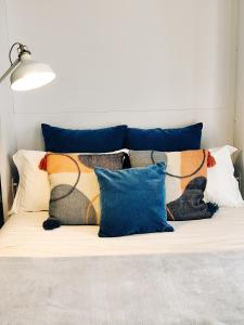 a bed with a bunch of pillows on it at Stressfree Apartamento in Vila Nova de Milfontes