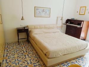 Un dormitorio con una cama, una cómoda y una mesa. en Villetta Ninì, en Isquia