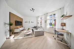 a white living room with a couch and a table at Helle, gemütliche Wohnung in Zentrumsnähe in Magdeburg