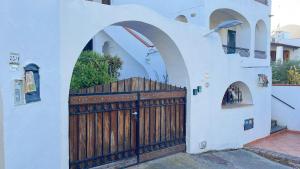 Casa blanca con puerta de madera con arcos en Villetta Ninì, en Isquia