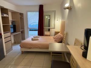 ein kleines Schlafzimmer mit einem Bett und einem Fenster in der Unterkunft Le Clos d'Aix Célony studio 9 parking in Aix-en-Provence