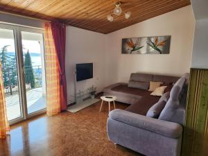 a living room with a couch and a tv at Apartment Frador in Portorož