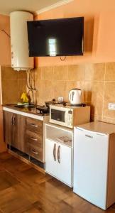 a kitchen with a stove and a white refrigerator at Aparts Tatiana Merlo San Luis in Merlo