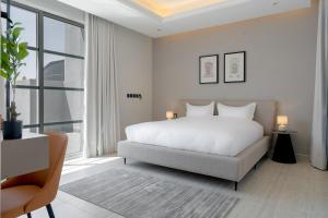 a bedroom with a white bed and a large window at أكاريم أفينيوز Akareem Avenues in Riyadh