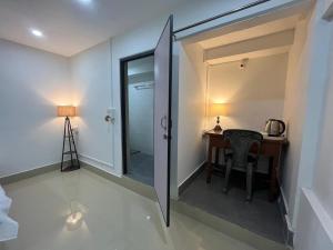 Una habitación con un escritorio y una puerta con una mesa. en Nagaon Homestay, en Nowgong 6 fotos más