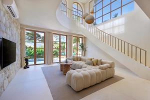 a living room with a couch and a staircase at 2 Bedroom Entire Place Villa Harmony Uluwatu Bingin in Uluwatu