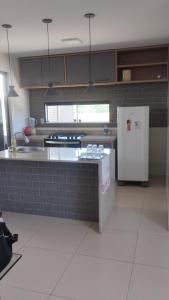 a kitchen with a white refrigerator in a room at Casa de Férias - Refúgio Arembepe in Camaçari