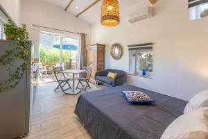 a bedroom with a bed and a table and chairs at Le Chant des Tongs - Les Oliviers in Salazac