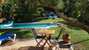 a table and chairs next to a swimming pool at Tamariu Chalet, 3 Bedroom in main house and self contained unit in Tamariu