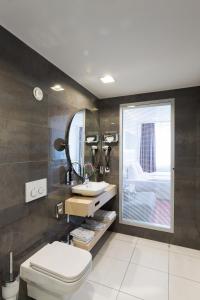 ein Badezimmer mit einem WC, einem Waschbecken und einem Spiegel in der Unterkunft Hotel Bayer's in München