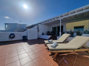a patio with two lounge chairs on a roof at Erizo de mar in Playa Blanca
