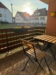 un banco de madera y una mesa de picnic en el balcón en L&K Apartment, en Metzingen