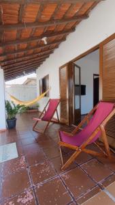 a patio with two chairs and a hammock at Casa em Ubatuba 1 km do aquário in Ubatuba