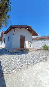 a small white house with a door in a yard at Casa em Ubatuba 1 km do aquário in Ubatuba +22 photos