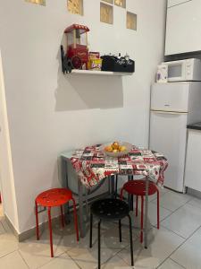 a kitchen with a table with chairs and a toy tractor on a wall at La perla del Colosseo in Rome +13 photos