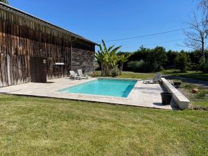 a swimming pool in a yard next to a building at La Tour du Sorbey - Gîte Nature Familial - Piscine - 3 à 6 Pax in Monségur