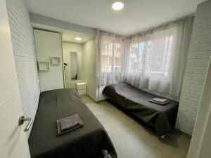 sypialnia z dwoma łóżkami i oknem w obiekcie New Square Ocean w mieście Benidorm