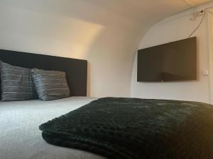 a bedroom with a large bed with a flat screen tv at Kinnarps Hem in Falköping