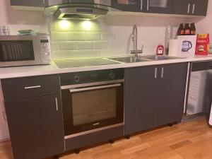 a kitchen with a stove and a sink and a microwave at Kinnarps Hem in Falköping