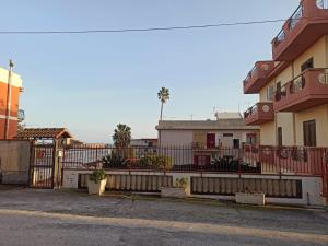 a building with a fence next to a street at HANNIE's HOUSE in Bova Marina