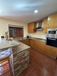 a kitchen with wooden cabinets and a counter top at Casa do Tio Quim in Castelo de Paiva