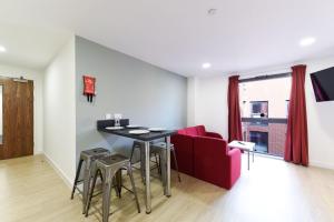 a living room with a table and a red couch at For Students Only Vincent Place in Southampton in Southampton +18 photos