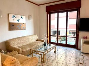 Una sala de estar con un sofá y una mesa de cristal. en home & pool 2, en Sorrento