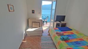 a bedroom with a bed and a couch and a television at Rooms Beba in Herceg-Novi