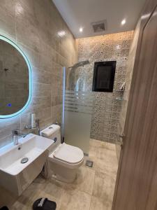 a bathroom with a white toilet and a sink at مساكن ورد الفندقية in Al Madinah +28 photos