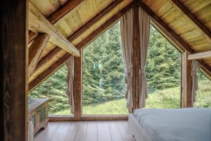 um quarto com uma cama e uma janela grande em Chata Pytlorka Beskydy offgrid wellness em Zahŭří