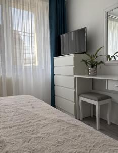 a bedroom with a bed and a dresser with a tv at Inga Apartment in Turda +10 photos