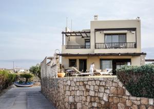 a man standing on the balcony of a house at Carpos Villa in Aegina Town