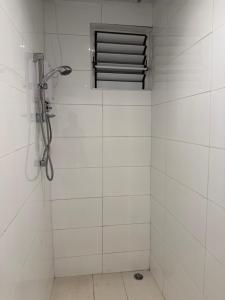 un bagno piastrellato bianco con finestra e doccia di Island Payless a Nadi Altre 11 foto