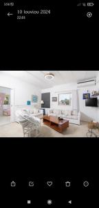 a living room with a couch and a table at Family House - Παραθεριστικό Κατάλυμα in Nea Plagia