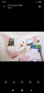 a bedroom with two beds and a window at Family House - Παραθεριστικό Κατάλυμα in Nea Plagia