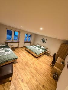 a large bedroom with two beds and a wooden floor at Ferienwohnung Ankerplatz in Schalkenmehren