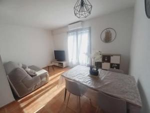 a living room with a table and a couch at 40 - Mazet de Provence dans village de vacances in Gaujac