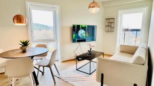 un salon avec une table et une télévision dans l'établissement Penthouse Apartment, à Kristiansand