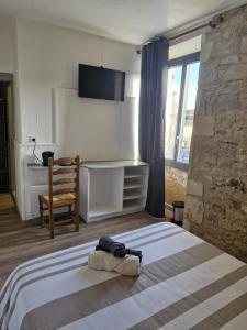 a bedroom with a bed with a chair and a desk at Eden Auberge in Villefranche-du-Périgord