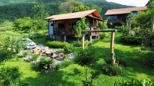 a house with a garden in front of it at Espaço Isha Canelinha in Canelinha